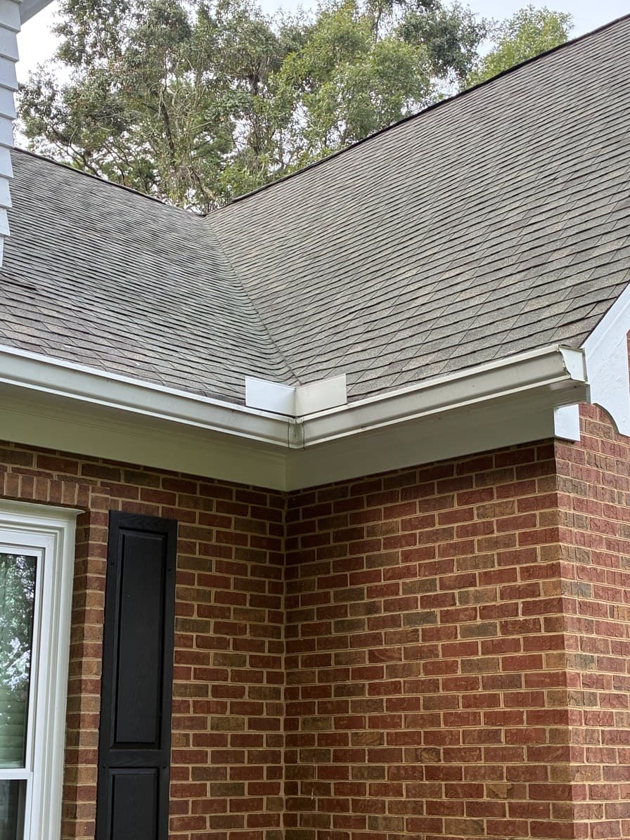 The same gutter run cleared to an open channel with the downspout head visible