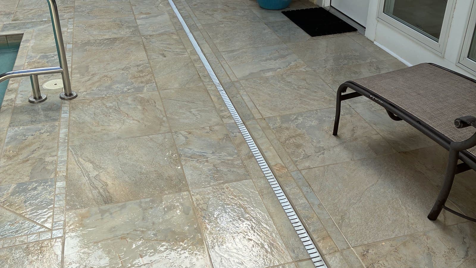 Pool deck cleaned to an even finish with the perimeter trench drain running clear